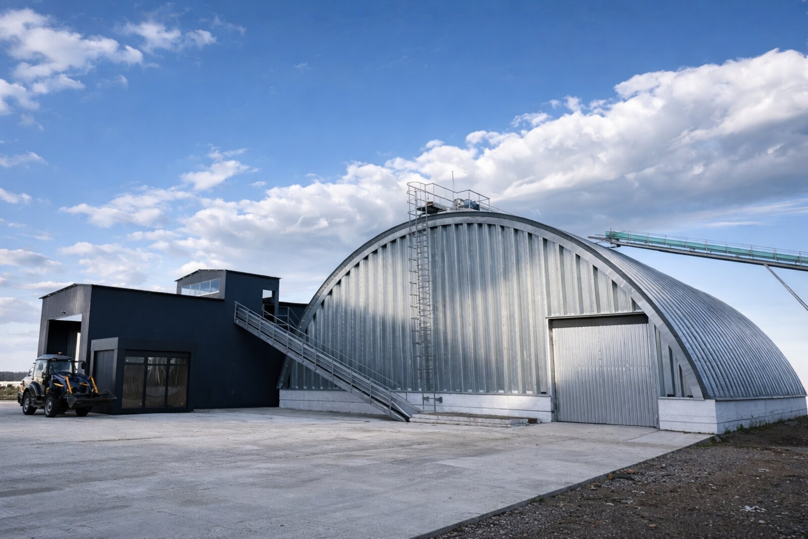 Арочний склад та зернові силоси на тлі неба